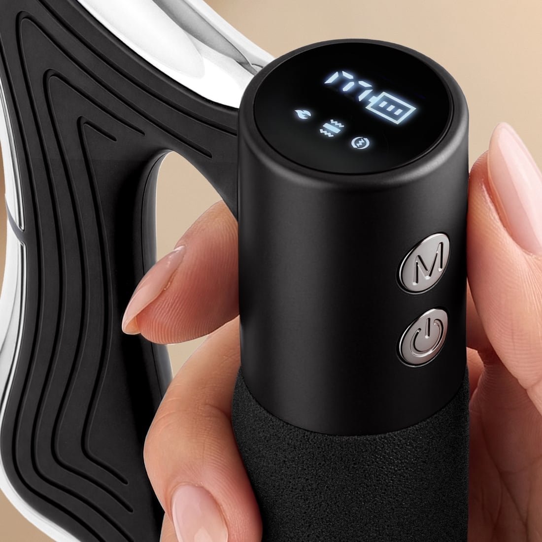 A hand holding the TOAI grip, thumb beside the M and power buttons, the OLED cap lit with mode icons and a battery indicator